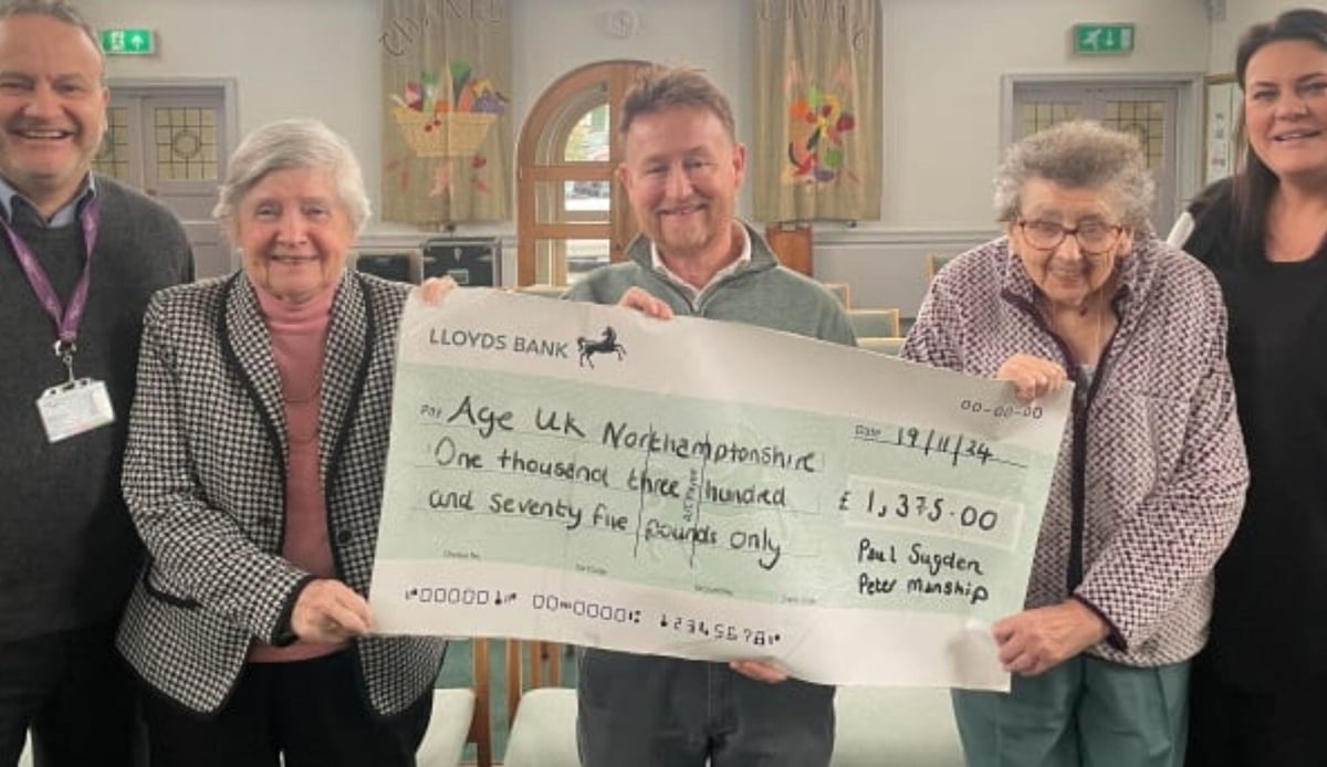 Paul receiving the large cheque for funds raised